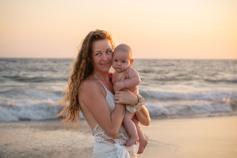 Mutter hält ihr Baby am Strand von Mazunte bei Sonnenuntergang