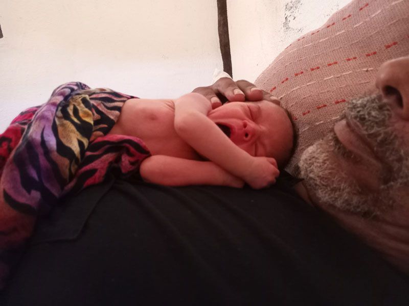 Neugeborenes Baby liegt auf der Brust eines Mannes in einer Hütte in Mazunte