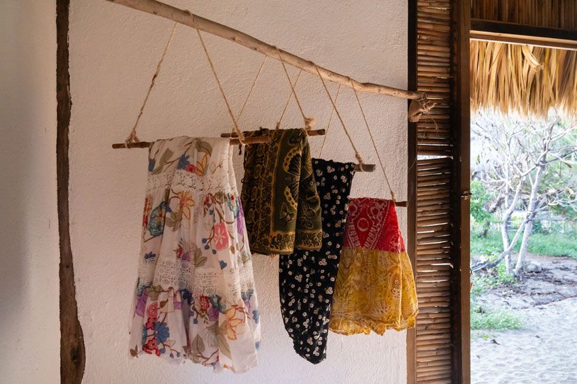 Bunte Tücher und Kleider hängen in einer Hütte in Mazunte